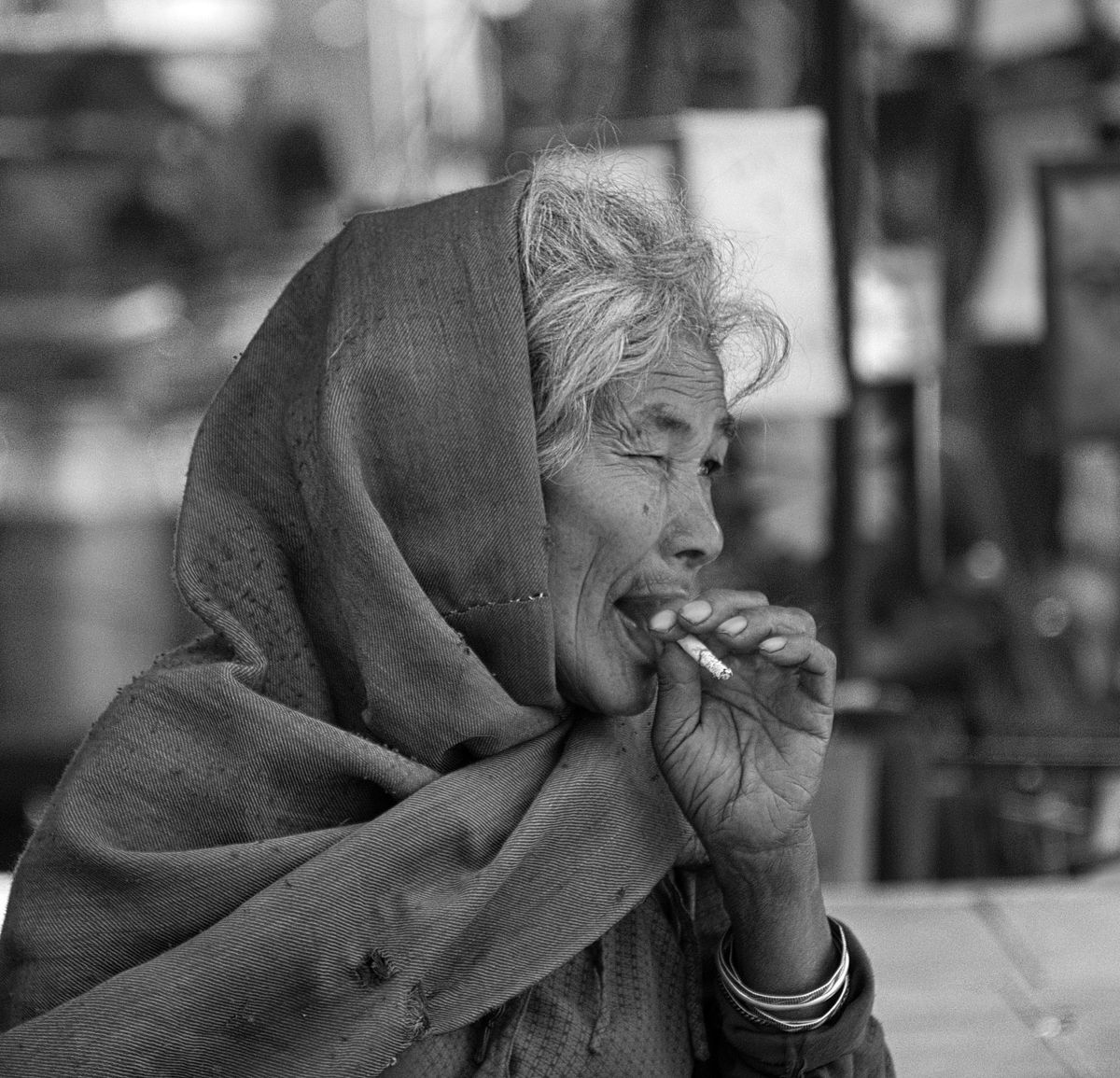 A old woman in Bhaktapur, Nepal, smokes a sigaret